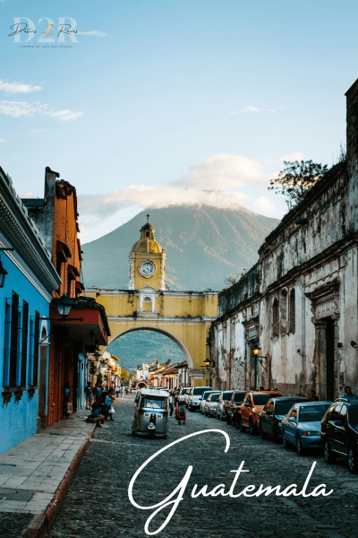 photo d'une rue au Guatemala avec l'horloge de la vie et la montagne derrière
